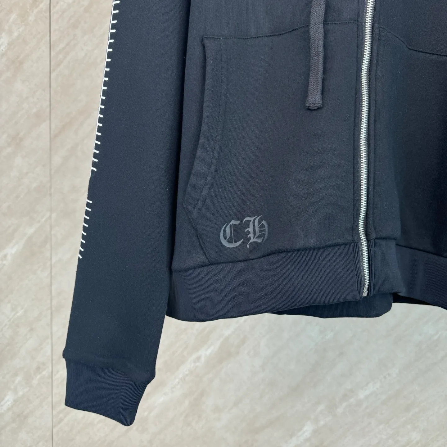 P460 Chrome Heart Ch character Sanskrit printed zipper hooded sweatshirt Size: S/M/L/XL Made of 80% cotton + 20% polyester blended fabric. The fabric is woven with 32-count base yarn and 10-count veil. The weight reaches 330 grams. It combines the skin-friendly breathability of cotton fiber and the anti-wrinkle stiffness of polyester. The sufficient weight brings good drape and wearing texture.